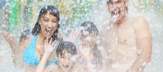 A family being sprayed by water at a park